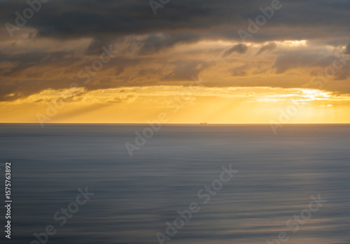 Wallpaper Mural Aerial view of gold sunlight piercing through dark clouds over tranquil ocean waters, Sellicks Beach, South Australia, Australia. Torontodigital.ca
