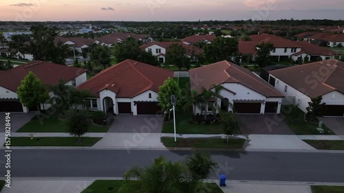 Wallpaper Mural Luxury villas with orange tiles on roof at sunset time. Luxury housing area with well-kept front yard in Sun city, Florida. Aerial lateral shot. Torontodigital.ca