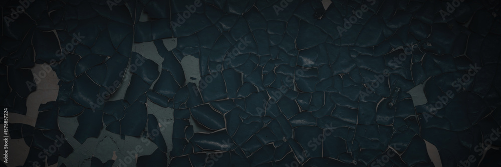 Fototapeta premium Dark wide panoramic background. Peeling paint on a concrete wall. Dark grunge texture of old cracked flaking paint. Weathered rough painted surface. Patterns of cracks. Darkness background for design.