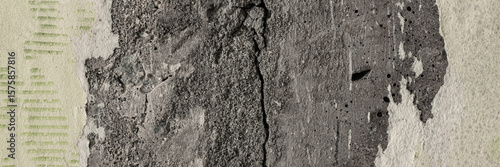 Torn old faded paper wallpaper with a retro pattern. Tattered scraps of paper on a concrete wall. Vintage texture for background and design. Closeup view with copy space.