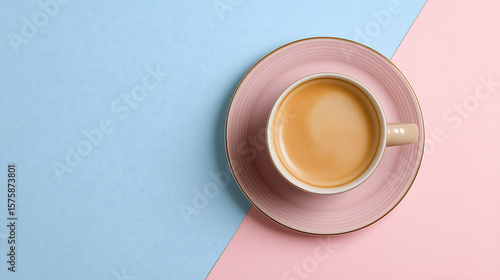 Coffee cup with creamy beverage sits on a pastel pink and blue background, showcasing a minimalist design that emphasizes tranquility and relaxation in a modern setting