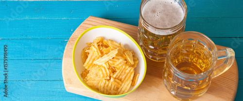 potato chips and two mugs of beer on the table