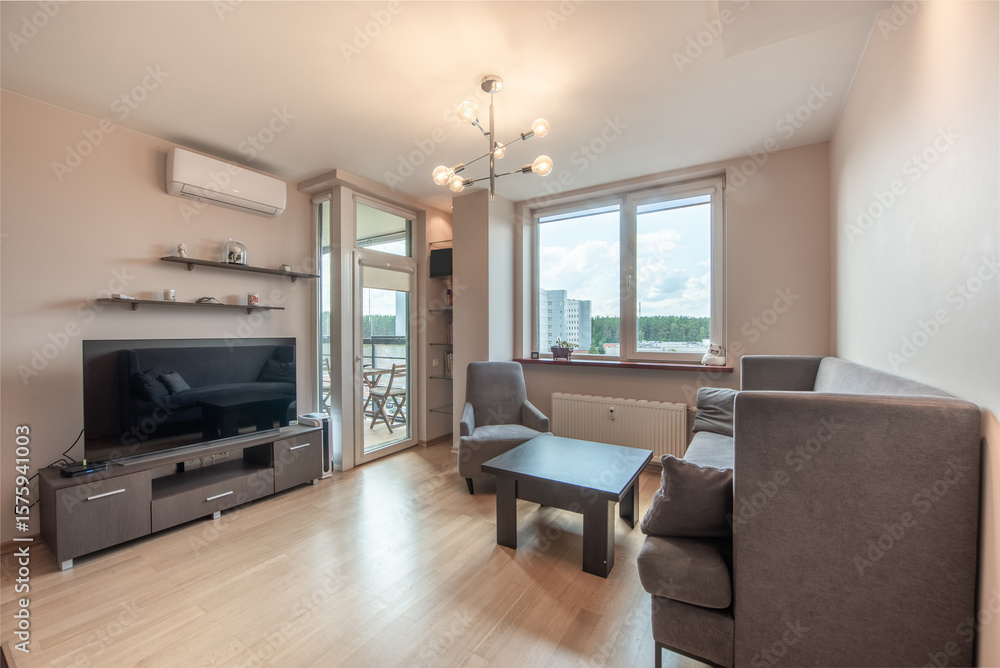 Modern Living Room With Stylish Furniture and Large Window Overlooking the Outdoors Modern Living Room With Stylish Furniture and Large Window Overlooking the Outdoors