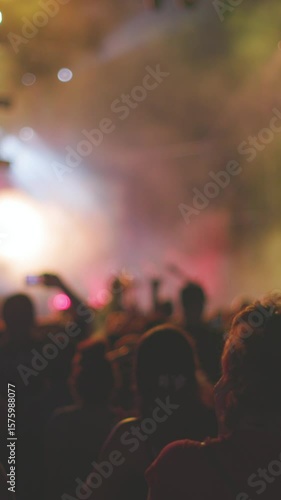 vertical shot. Passionate audience enjoying energetic rock show with raised hands, flashing lights and powerful atmosphere. feeling of live music and concert culture.