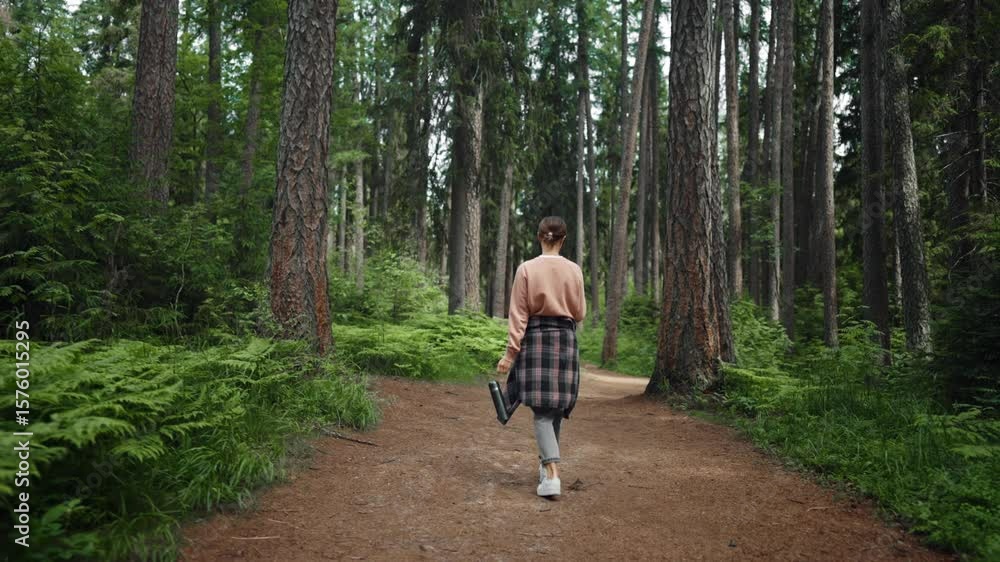 Hiking in woodland in summer vacation, back view of lonely lady strolling alone. Carefree female traveler exploring and discovering new location in beautiful coniferous forest, slow motion shot Hiking in woodland in summer vacation, back view of lonely lady strolling alone. Carefree female traveler exploring and discovering new location in beautiful coniferous forest, slow motion shot