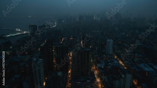 Night Cityscape: An aerial view of a city at night, showing a dense collection of buildings and streets, with scattered lights illuminating the darkness.