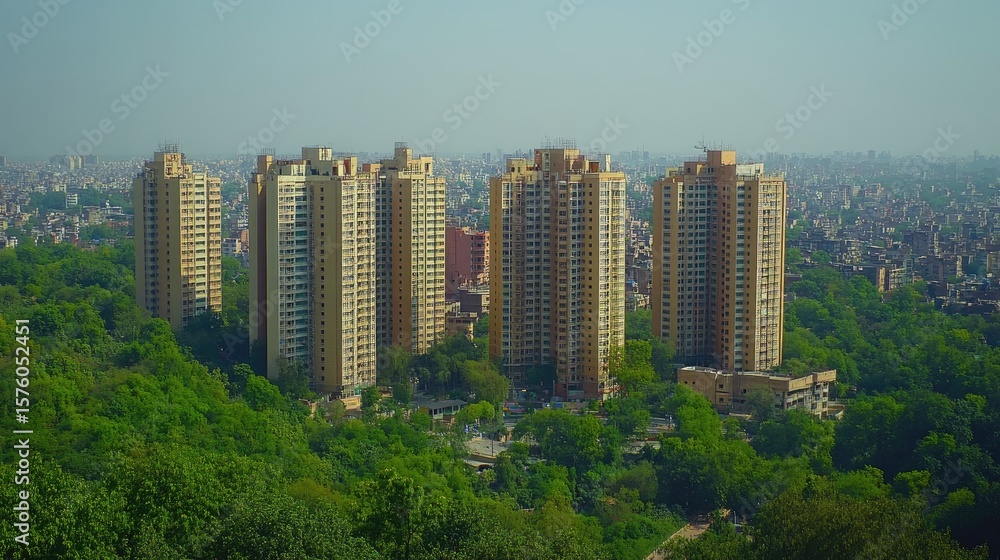 Fototapeta premium High-rise buildings amidst a lush green landscape.