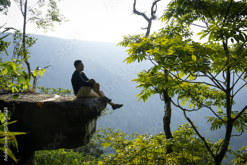 man sitting on the edge of a cliff