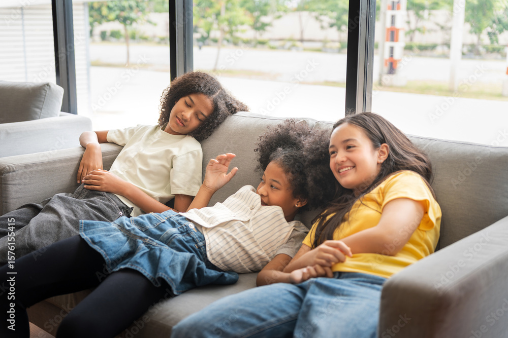Happy Diverse Teen Girls Relaxing on Sofa by Window, Three Smiling Young Friends Lounging Together Indoors, Multi-Ethnic Girls Enjoying Leisure Time Happy Diverse Teen Girls Relaxing on Sofa by Window, Three Smiling Young Friends Lounging Together Indoors, Multi-Ethnic Girls Enjoying Leisure Time