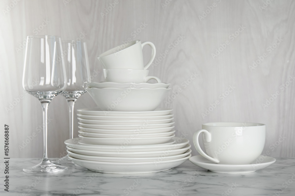 Fototapeta premium Different clean dishware on white marble table indoors