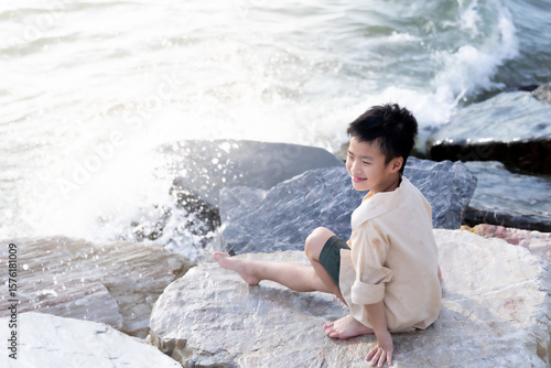 young boy sitting on rocks