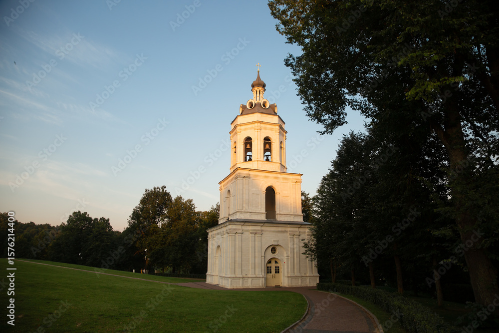 Obraz premium Beautiful old bell architecture building from white marble on nature bright sunny sunset light and blue sky background in the summer park on the hill