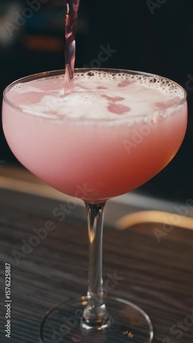 close-up view cocktail in restaurant. barman behind counter makes cocktails with ice. ice cubes in margarita glass. bartender shakes shaker. special serving alcoholic cocktail. drops fall into glass