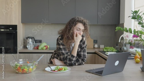 Focused Female Watching Laptop During Healthy Meal In Bright Cozy Kitchen