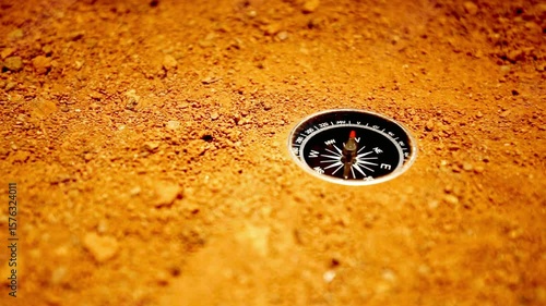 A compass rests on the sandy ground, ready for adventure