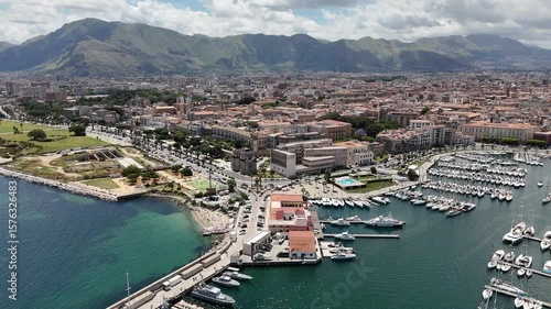 Sorvolo aereo con drone porto turistico darsena con vista barche a vela al tramonto della cala di palermo che evidenziano inquinamento in un paesaggio mozzafiato dello skyline della città antica 