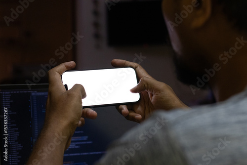Hand holding landscape view of the smart phone with white background in the home office