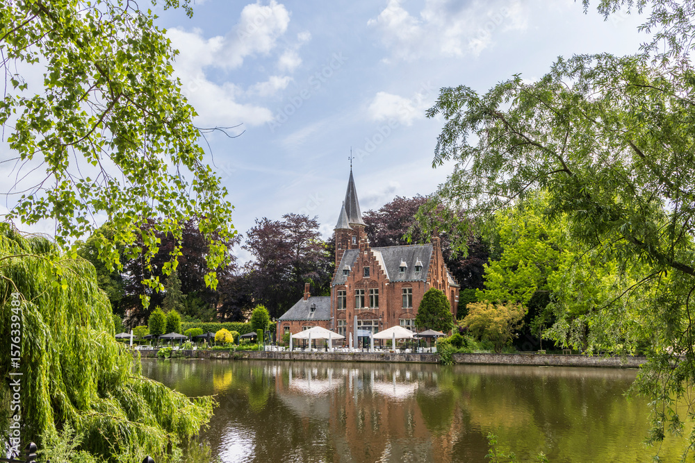 Minnewater lake and castle with foliage frame in Brugge in Flanders Belgium Minnewater lake and castle with foliage frame in Brugge in Flanders Belgium