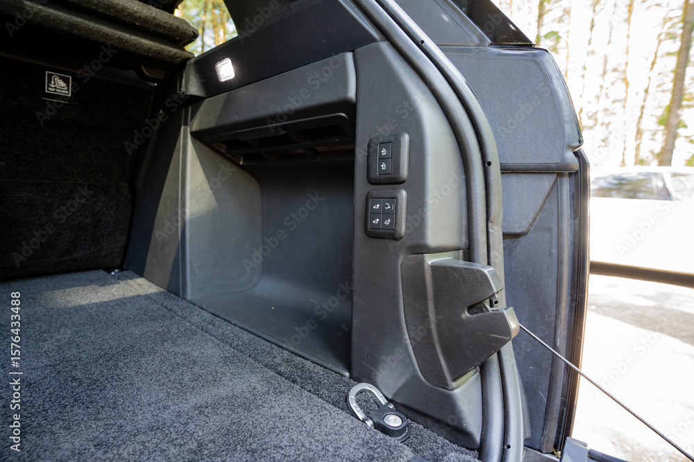 Fototapeta premium This is an interior view of a modern SUV focusing on the cargo area, which features a welldesigned storage compartment along with various controls that enhance functionality and organization