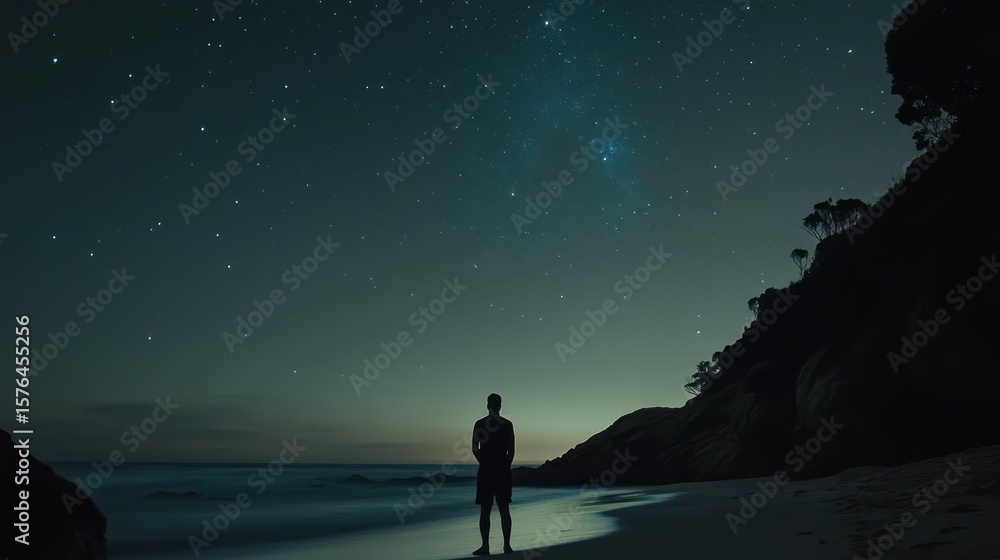 Fototapeta premium Man gazing at starry night sky over beach