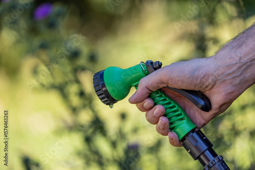 A hosepipe being held but switched off, with a shallow depth of field