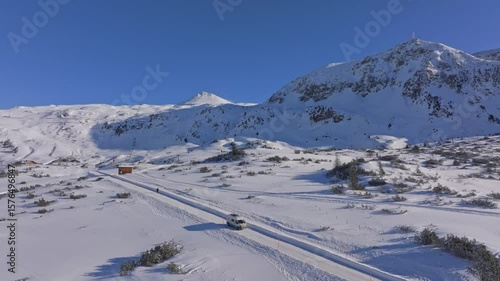 Aerial view of camper van traversing snow-clad streets of Obertauern