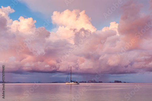 Fototapeta Naklejka Na Ścianę i Meble -  Sailboat anchored near Koh Kradan island in Andaman Sea, South Thailand. Dramatic sunset clouds. Tropical landscape.