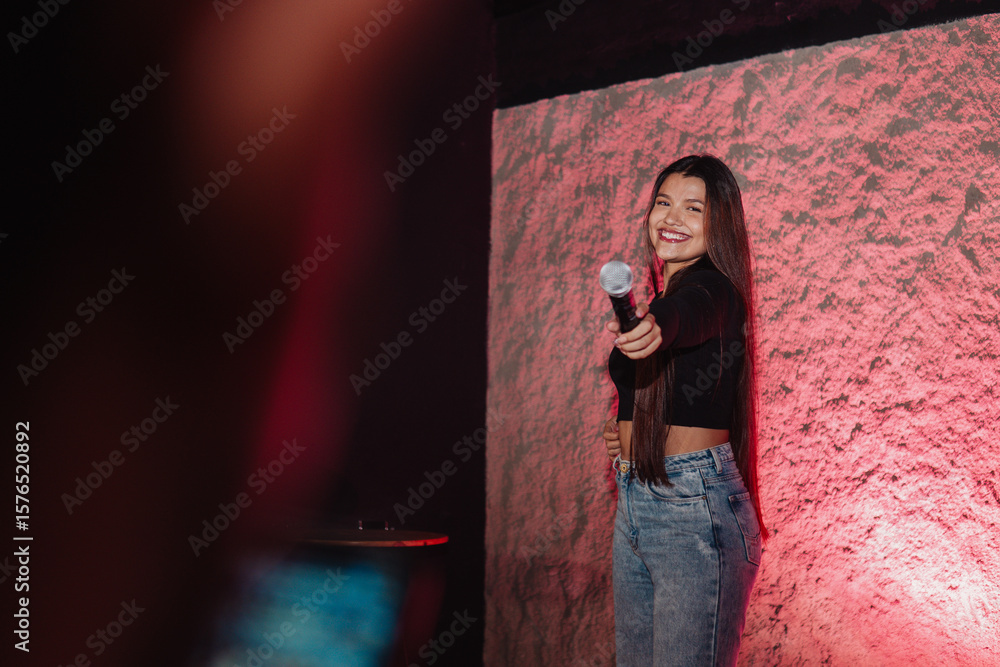 Obraz premium beautiful young Latina woman with a microphone in karaoke or singing