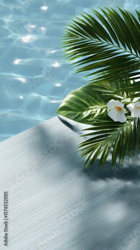 Bright Tropical Palm Leaves and White Flowers Beside a Sparkling Blue Swimmin...