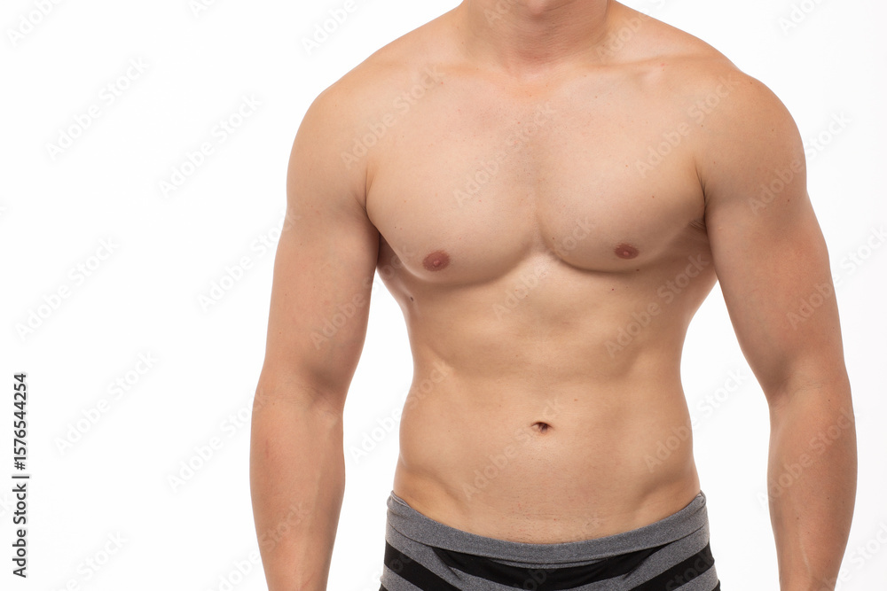 A young athletic guy with an athletic build and a smooth body poses against a white isolated background after shaving. athlete's torso in underwear. Concept: diet, men's health, fitness A young athletic guy with an athletic build and a smooth body poses against a white isolated background after shaving. athlete's torso in underwear. Concept: diet, men's health, fitness