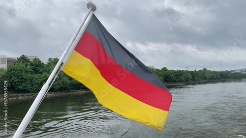 German national flag flying over Danube river water on boats pole on a cloudy stormy summer day