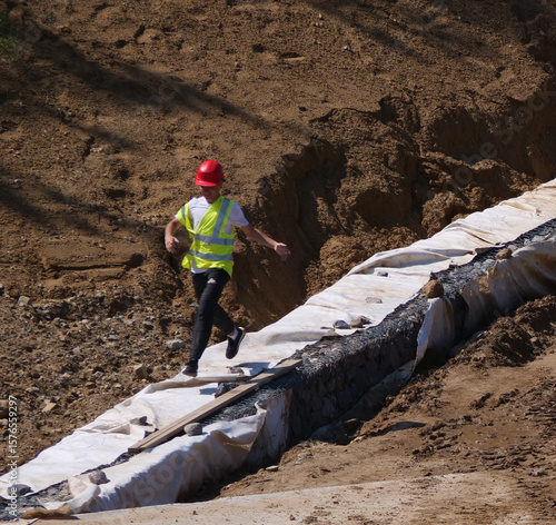 Energetic Construction Worker Running Down Trench at Earthworks Development Site