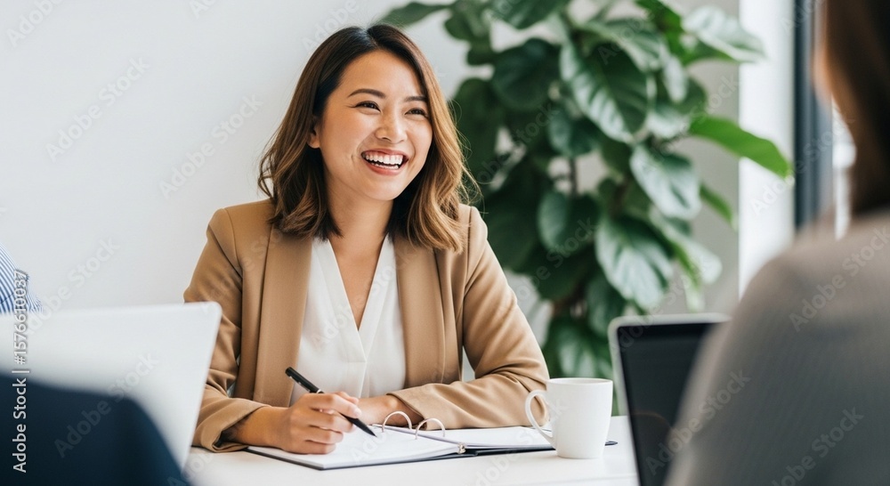 Fototapeta premium Smiling businesswoman takes notes during a meeting with her colleagues