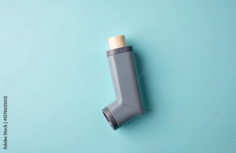 Close-up of grey asthma inhaler on bright blue background. Medical device for respiratory health, allergy relief. Compact portable medicine container for lung treatment therapy. Close-up of grey asthma inhaler on bright blue background. Medical device for respiratory health, allergy relief. Compact portable medicine container for lung treatment therapy.