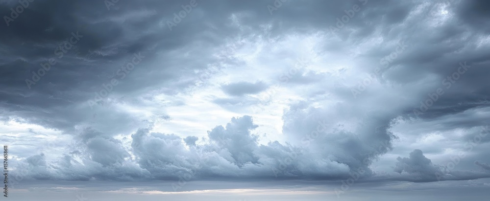 Obraz premium Dramatic cloudy sky with thick, textured dark and light gray clouds creating a moody and intense atmosphere