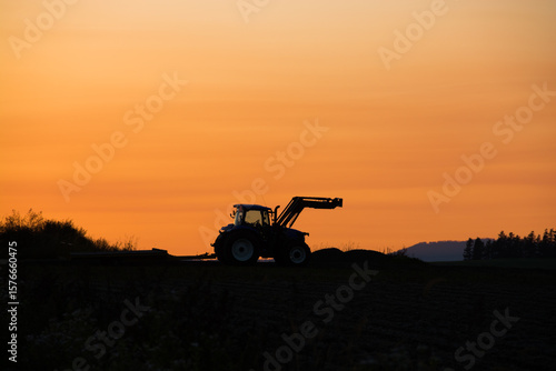 秋の夕焼空とトラクターのシルエット