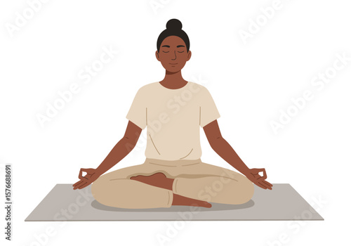 A serene Black woman with her hair in a bun sits in a lotus pose on a yoga mat, meditating with her eyes closed.