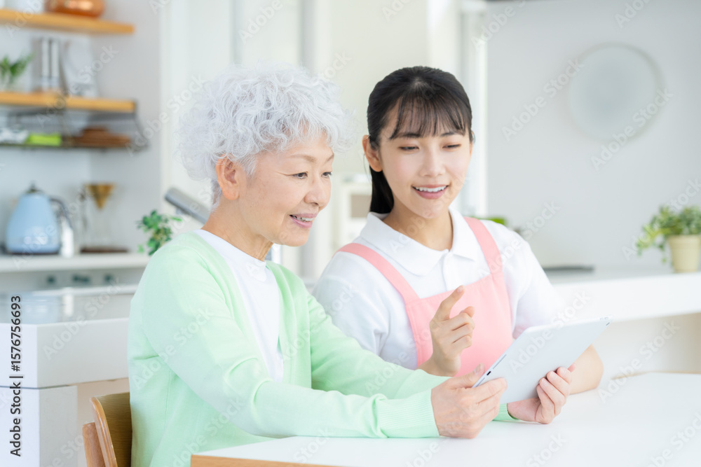 Fototapeta premium リビングで介護をする若い女性介護士