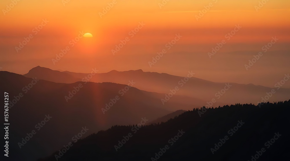 Fototapeta premium Smoky sunset over silhouetted mountain range