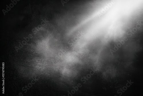 Floating dust particles captured in a black matte textured background with a beam of light enhancing the ethereal atmosphere during a quiet moment of reflection
