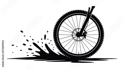 Black silhouette of a mountain bike wheel kicking up dirt and water splash