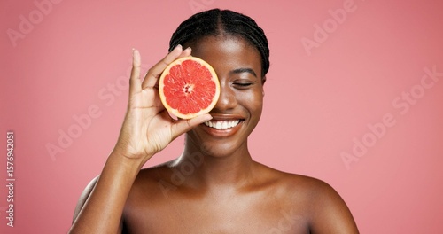Tableau sur toile Smile, black woman and grapefruit for skincare in studio for vitamin c, brighten skin and natural detox