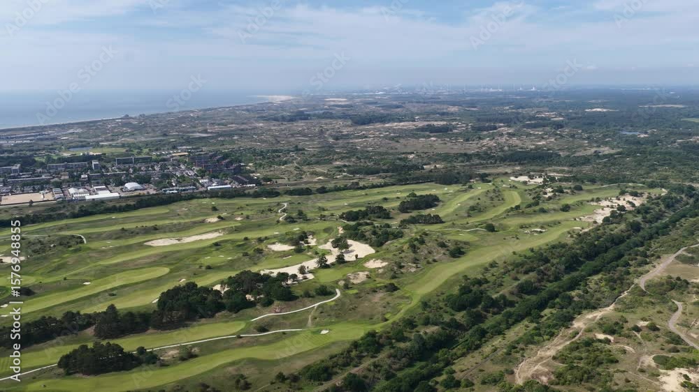 Drone view of Kennemer Golf Country Club in Zandvoort, surrounded by dunes, town, and coastline Drone view of Kennemer Golf Country Club in Zandvoort, surrounded by dunes, town, and coastline
