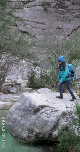 Wide shot of a mexican woman in a rock over a river