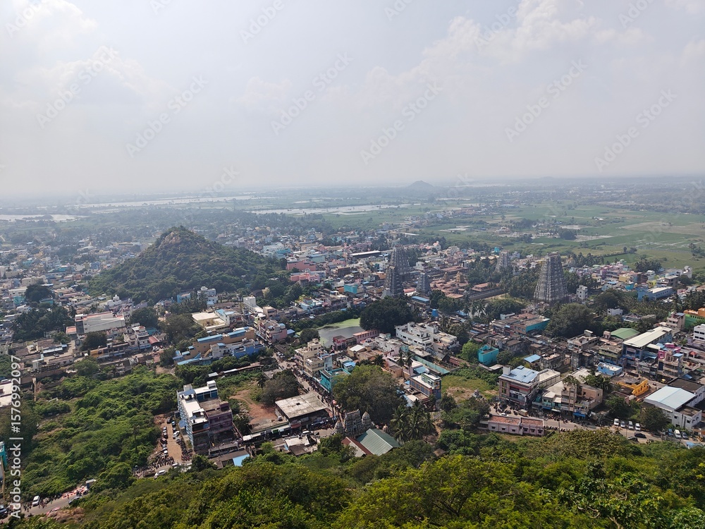 Obraz premium A spiritually resonant view of Thirukazhukundram, Tamil Nadu, India, capturing both the hilltop Vedagiriswarar Temple and the ancient foothill temple complex. The hill temple, dedicated to Lord Shiva,