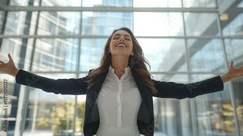 Confident businesswoman arms outstretched joyful success modern office building sunlight happiness achievement professional Free Download Confident businesswoman arms outstretched joyful success modern office building sunlight happiness achievement professional - GFXLoad
