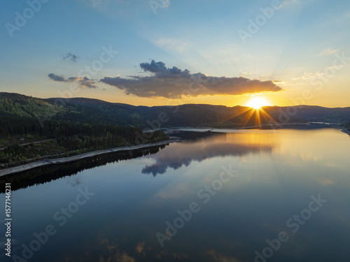 Wallpaper Mural Aerial view of the sun's golden rays kissing the tranquil lake, reflecting off the water like liquid gold, while the forest stands guard in deep emerald hues, Schluchsee, Baden-WÃ¼rttemberg, Germany. Torontodigital.ca