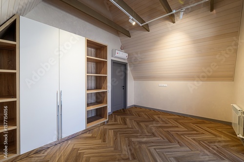 фотографія Attic room with herringbone floor, built-in wardrobe, and sloped ceiling