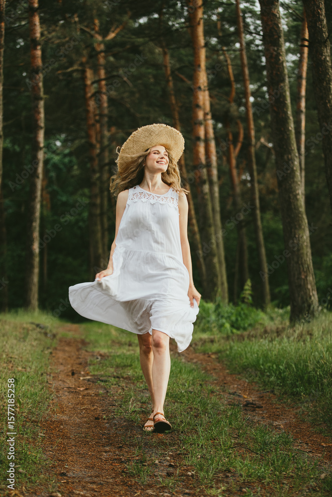 Tourist walking in forest wearing white dress and straw hat Tourist walking in forest wearing white dress and straw hat