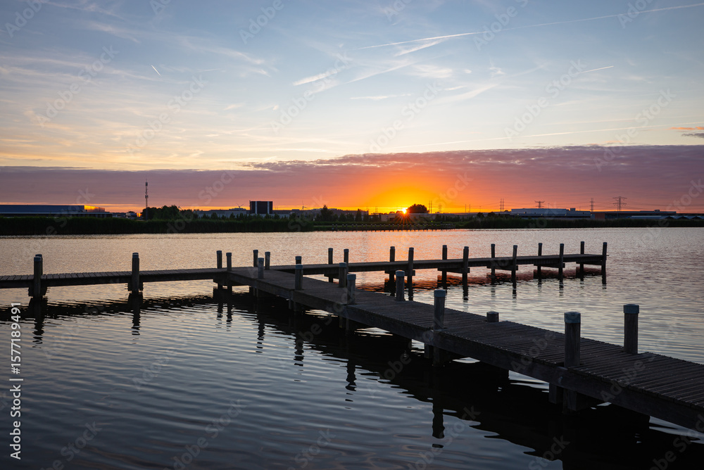 Fototapeta premium Scenic view of a wooden jetty at river Rotte, western Netherlands at sunset